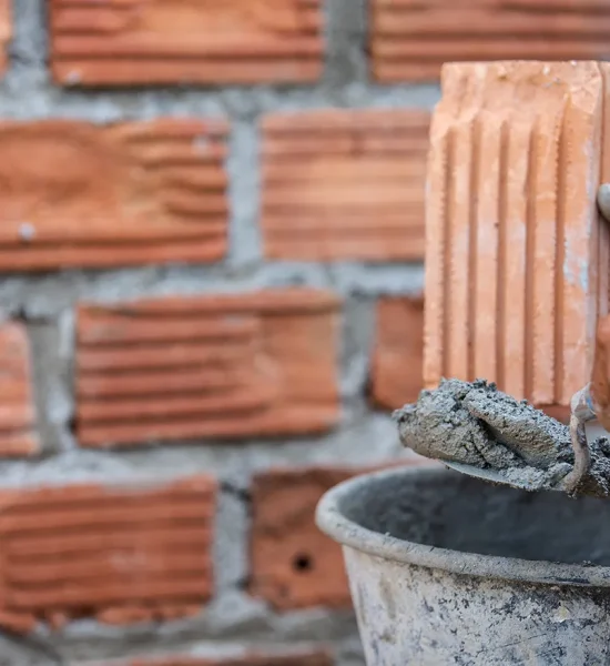 masonry-worker-outside-wall-with-trowel-knife copia
